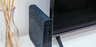 Nowoczesny salon z routerem Wi‑Fi, telewizorem i szklaną dekoracją