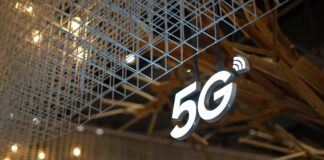 Podświetlony napis 5G na tle nowoczesnego, geometrycznego sufitu