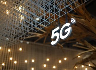 Podświetlony napis 5G na tle nowoczesnego, geometrycznego sufitu