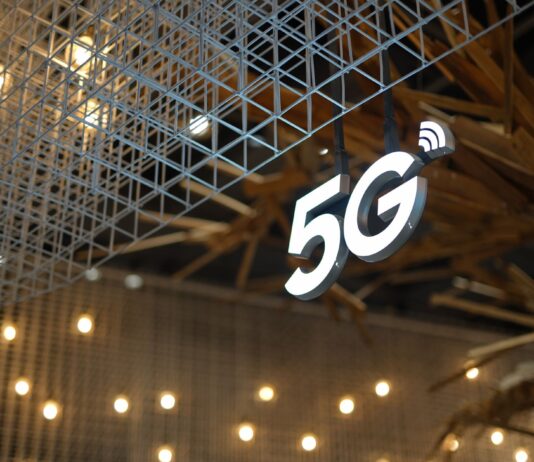 Czy 5G jest bezpieczne dla zdrowia oraz jak wpływa na prywatność użytkowników internetu Podświetlony napis 5G na tle nowoczesnego, geometrycznego sufitu
