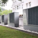 Szereg pomp ciepła ustawionych przy ścianie budynku jednorodzinnego