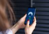 Kobiece dłonie uruchamiają aplikację VPN na smartfonie