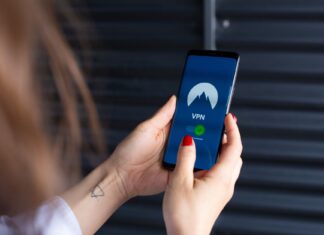 Kobiece dłonie uruchamiają aplikację VPN na smartfonie