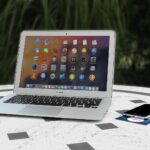 Laptop i smartfon na białym stole w plenerze podczas korzystania z internetu