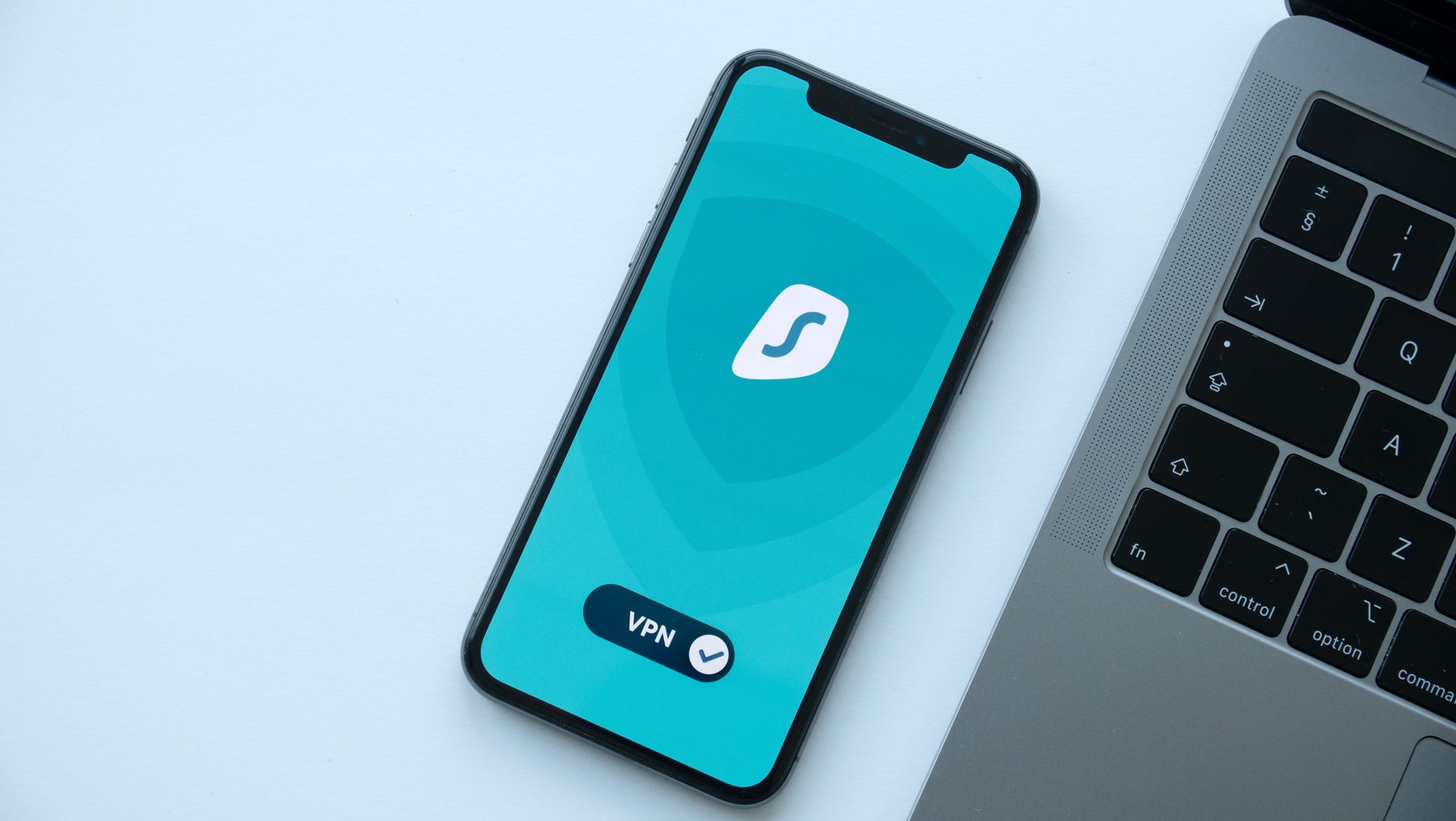 Smartfon z włączoną aplikacją VPN obok laptopa na biurku