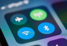 eSIM w Polsce 2026: jak działa cyfrowa karta w sieci mobilnej Zbliżenie na panel sterowania smartfona z ikonami Wi‑Fi i Bluetooth