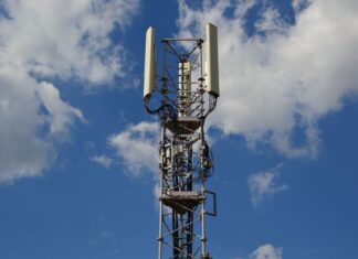 Brak internetu mimo pełnego zasięgu LTE/5G na telefonie: jak zdiagnozować usterkę? Wieża telekomunikacyjna na tle błękitnego nieba